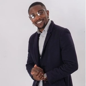 Atelier de réparation automobile moderne avec deux mécaniciens en combinaisons bleues examinant le moteur d'une berline grise, capot ouvert